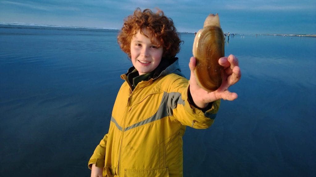 Boy holding a razor clam