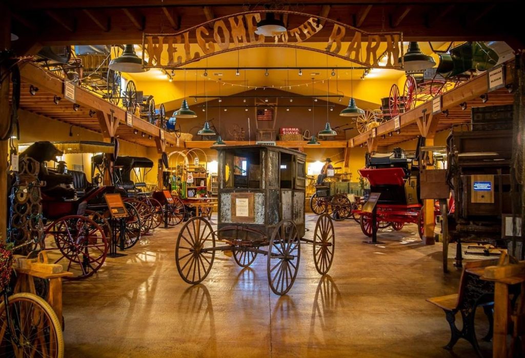 Explore family-friendly activities in Long Beach at the Northwest Carriage Museum, featuring a rustic barn setting with antique horse-drawn carriages, wagons, and historical artifacts on display.