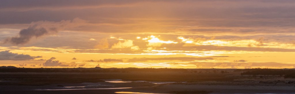 A wide-shot of a sunset over a sprawling landscape in Tokeland.